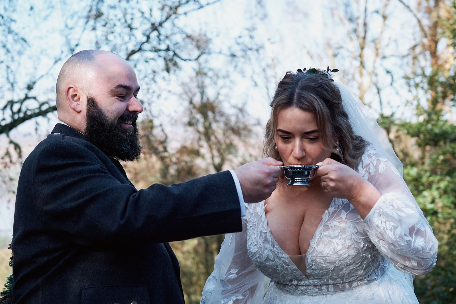 The couple sharing a drink from a quaich