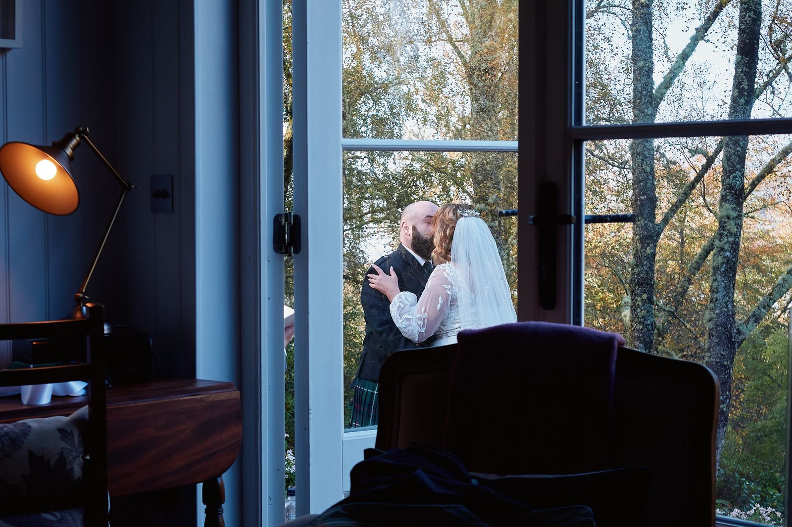 The couple silhouetted in a cottage doorway, seen from inside