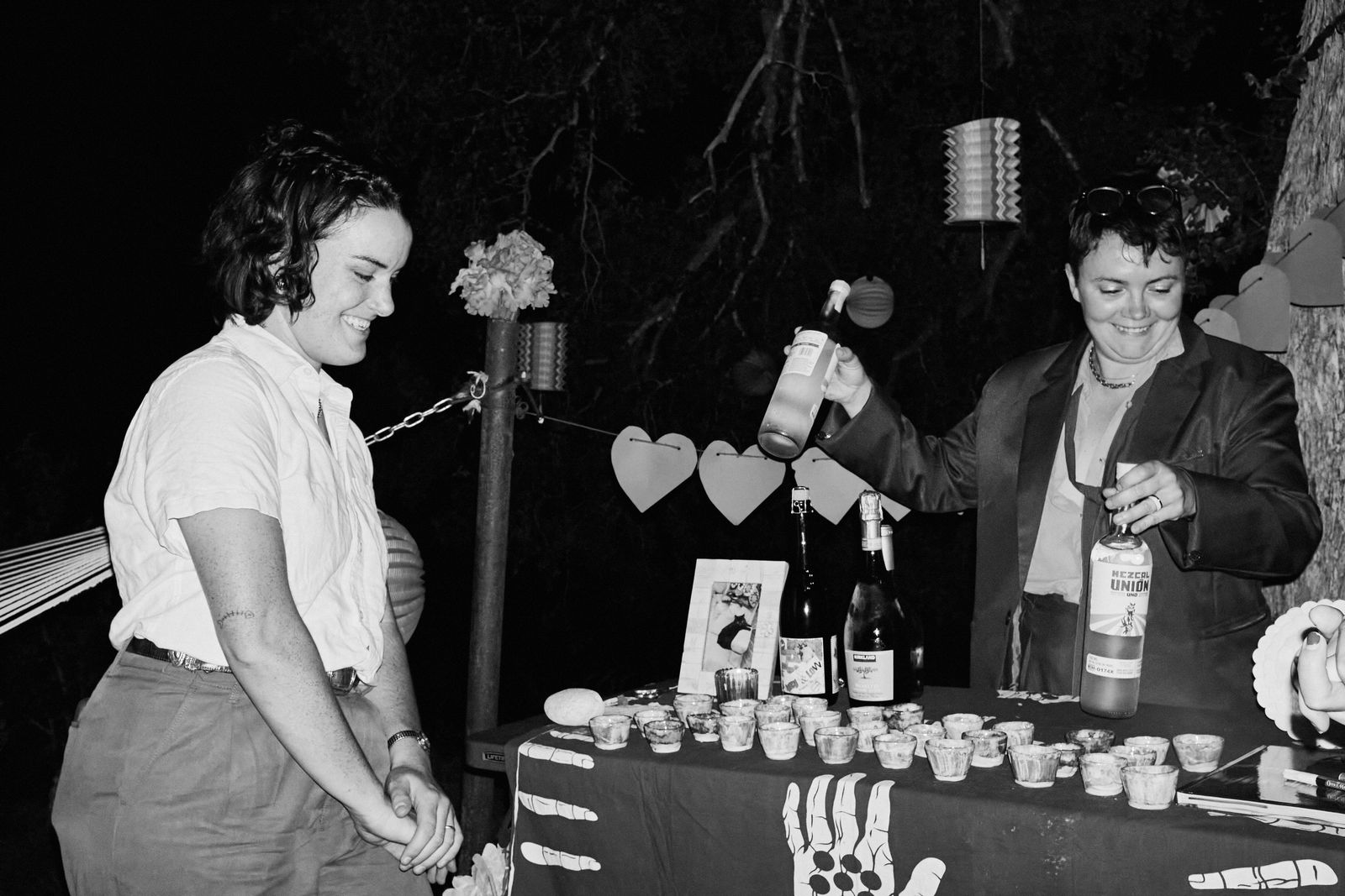 Black-and-white photo of a couple pouring drinks at an evening reception