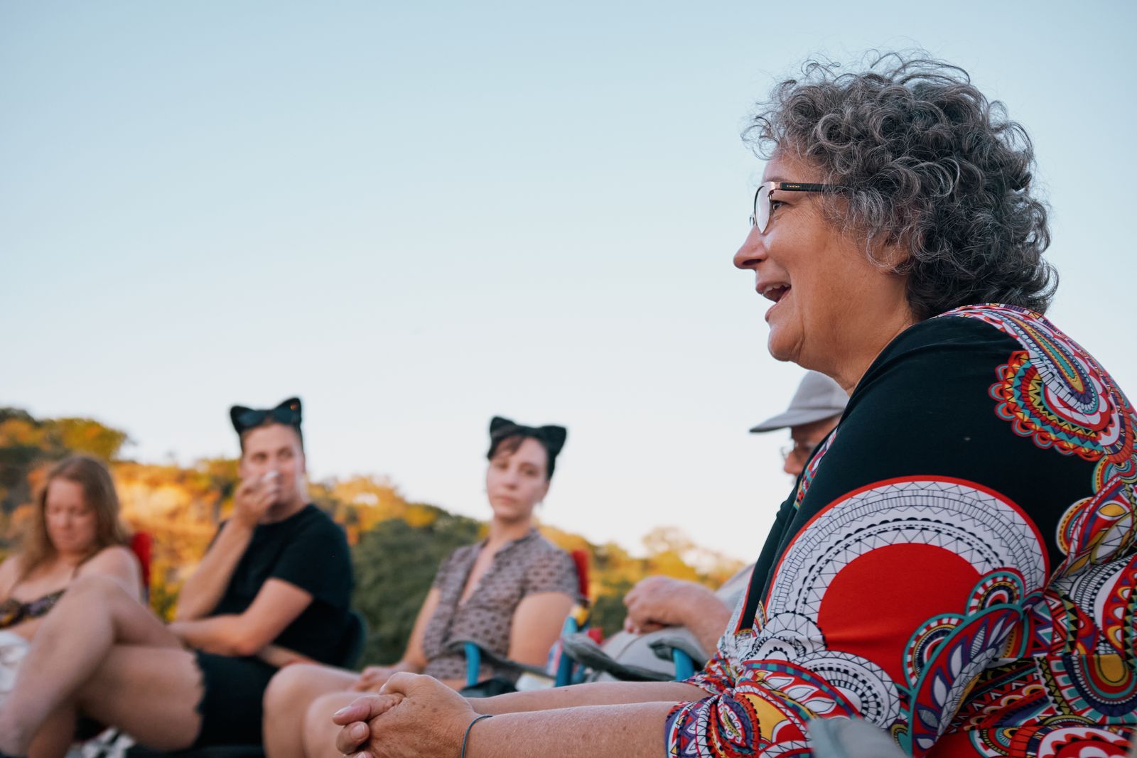 A guest in a patterned top laughing during the Quaker-style ceremony