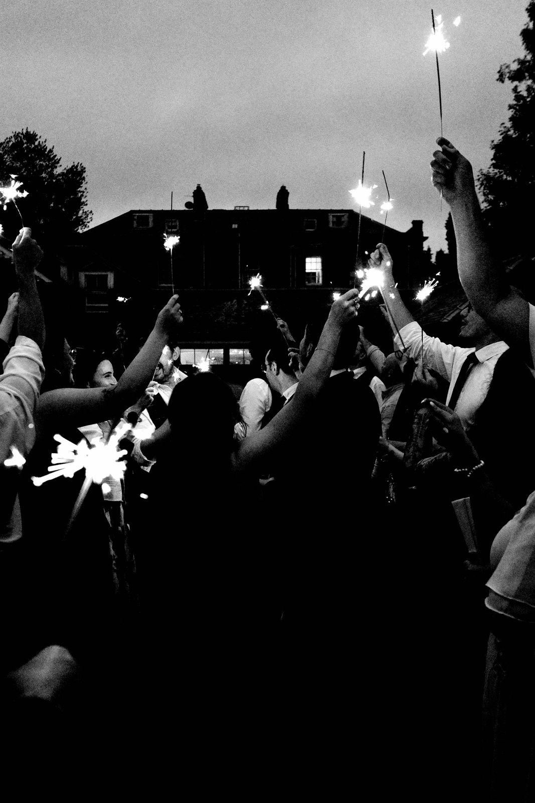 Black-and-white photo of wedding guests holding sparklers